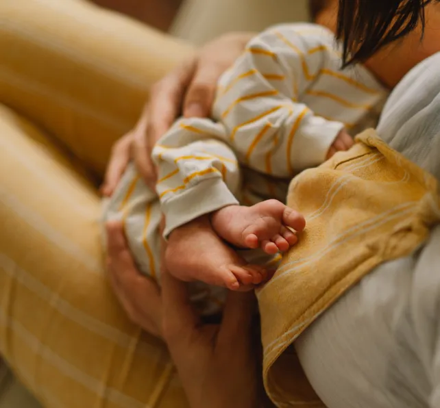 Mother holding newborn baby in a hospital, discussing birth injury concerns