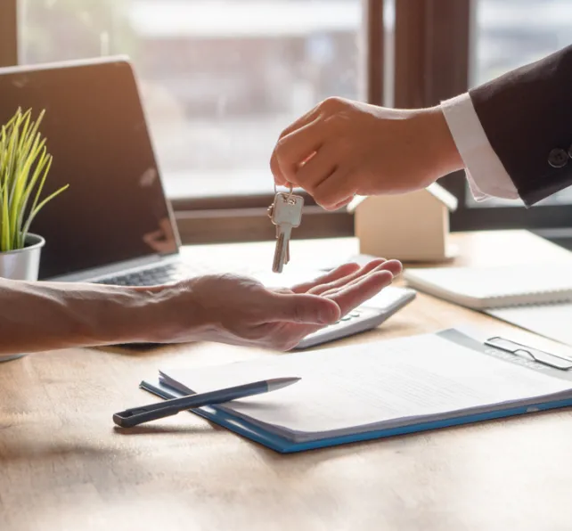 Realtor agent giving a key of apartment to new owner after signed lease agreement.