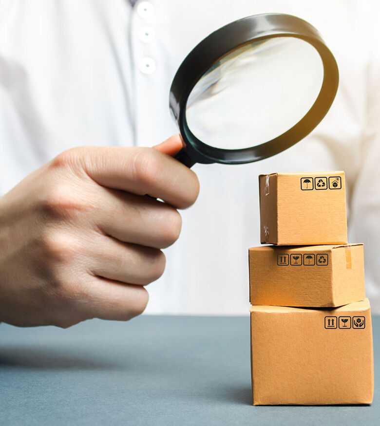Product Liability Lawyers in Hilton Head, SC - A man holds a magnifying glass above the boxes