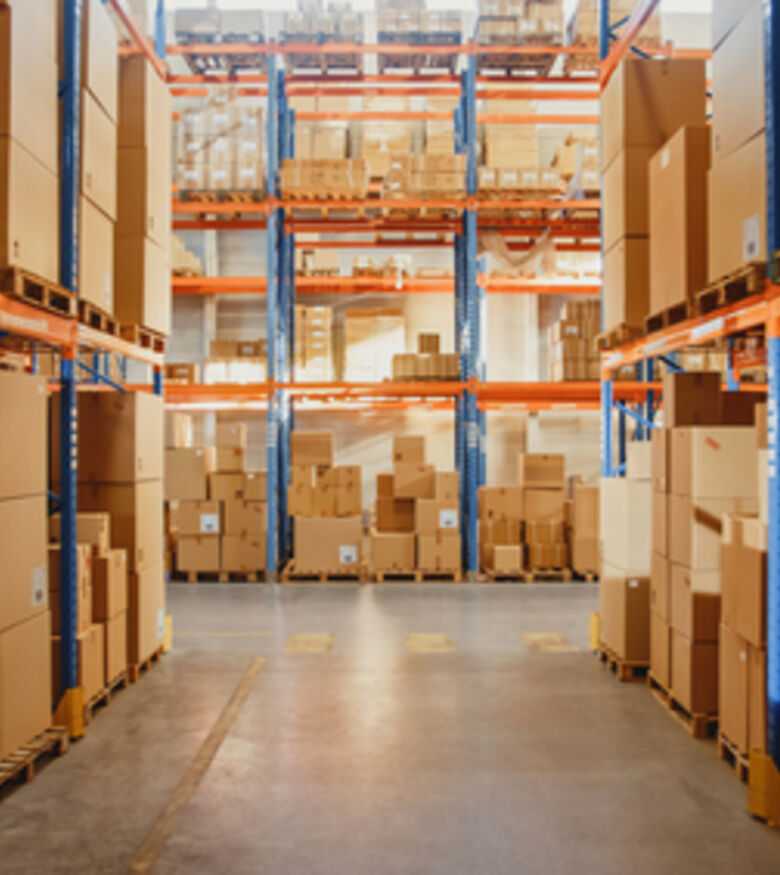 Industrial warehouse interior with high shelves stacked with cardboard boxes for storage and logistics