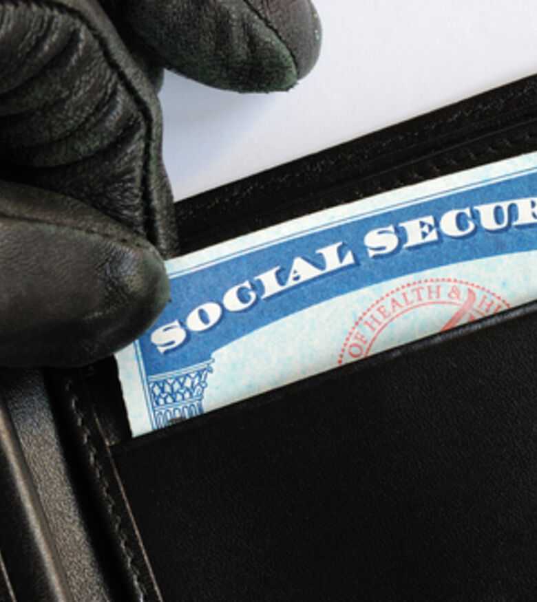 Gloved hand extracting a social security card from a wallet