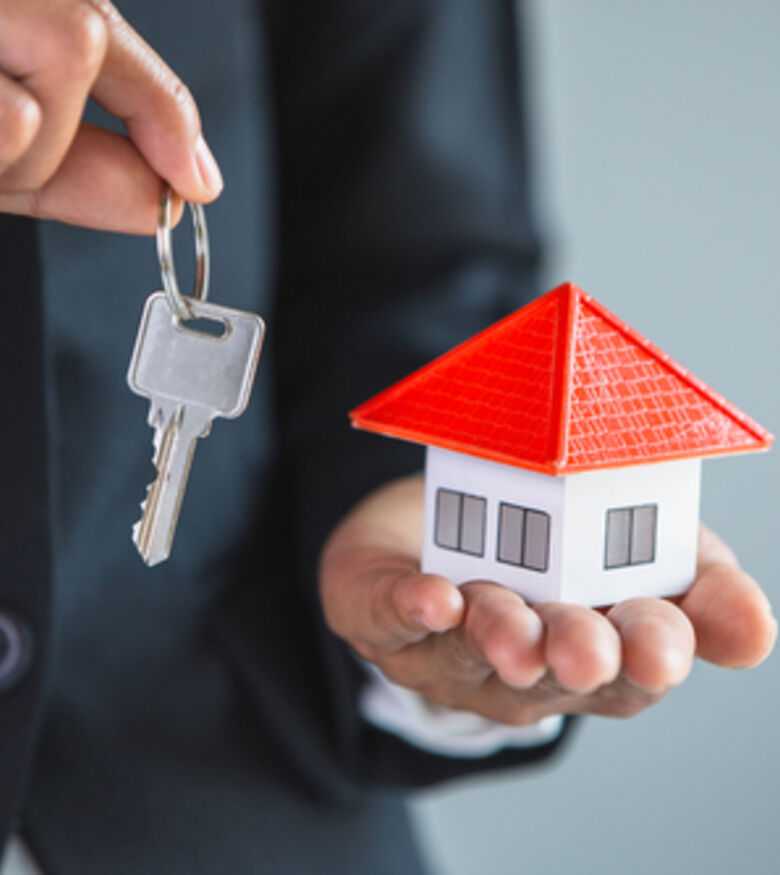 Real estate agent holding house model and keys