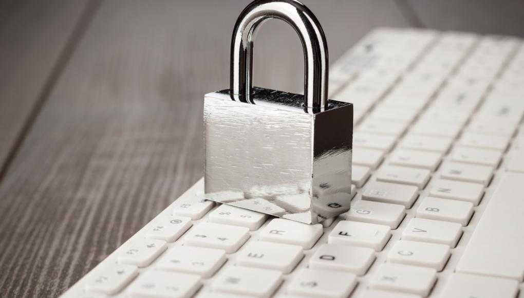 padlock and white computer keyboard on the wooden office table. privacy protection, encrypted connection concept