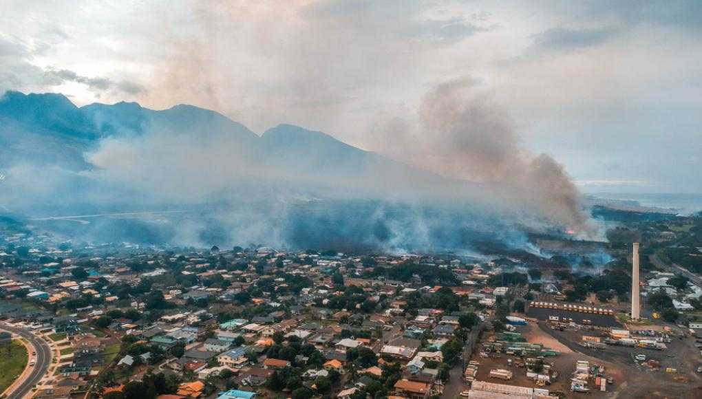 Arial view of smoke rising from a residential area in Maui due to wildfires