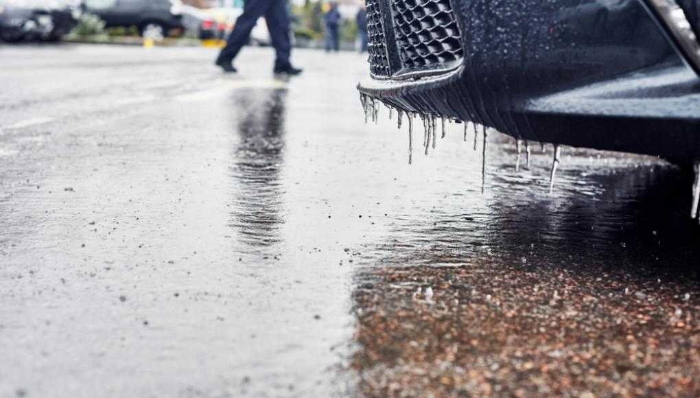 Icicles hanging off of a car in a parking lot