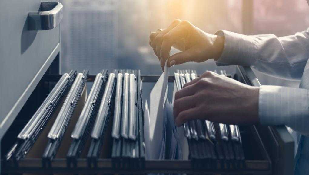 Person looking through files in a filing cabinet