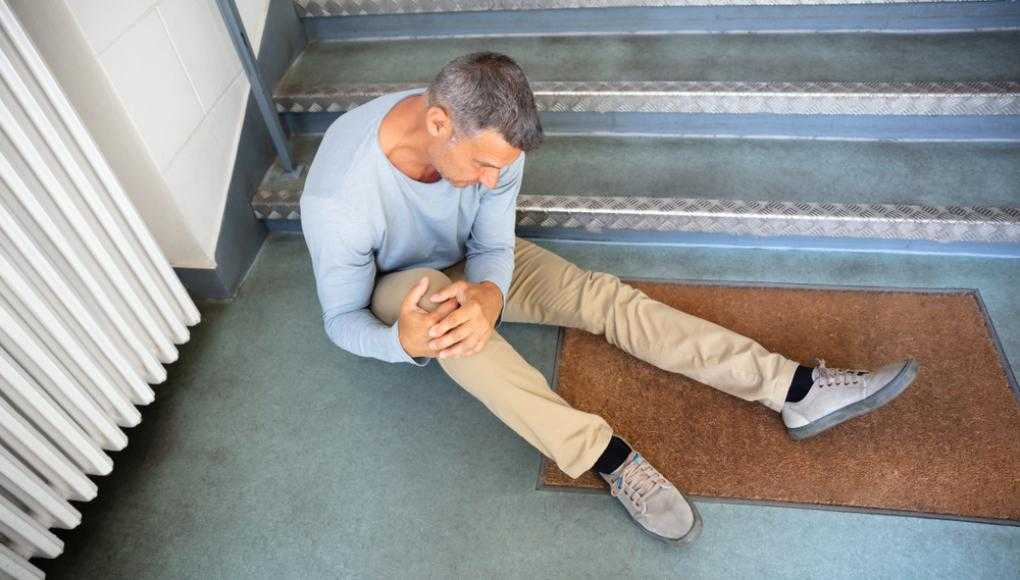 Man holding knee in pain on the floor