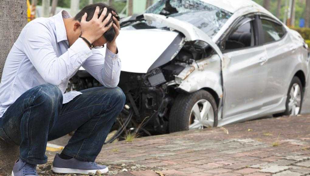 Man with his head in his hands after a car accident