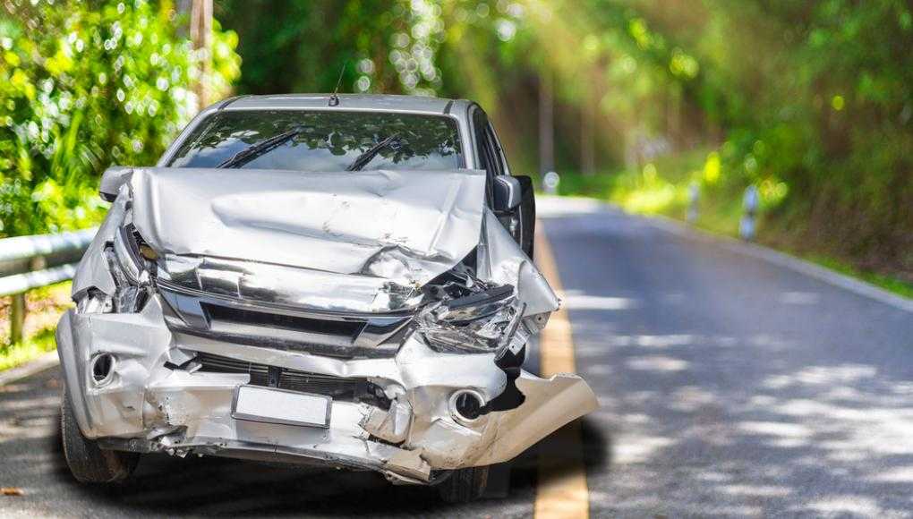 Grey car with damage on the road 