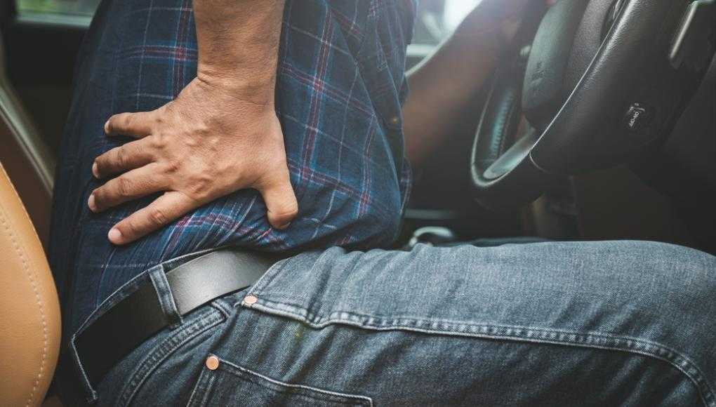 Man with back pain in his car