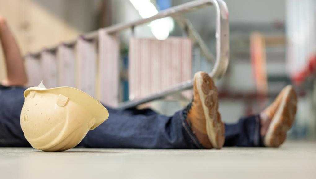 Worker fallen down next to ladder