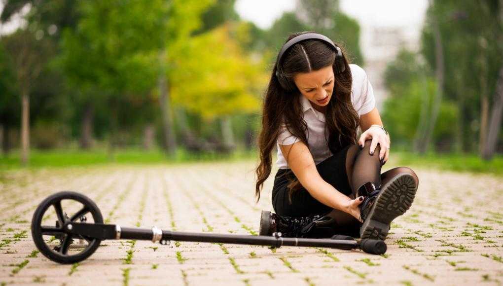 Woman on ground suffering a Scooter Ankle Injury