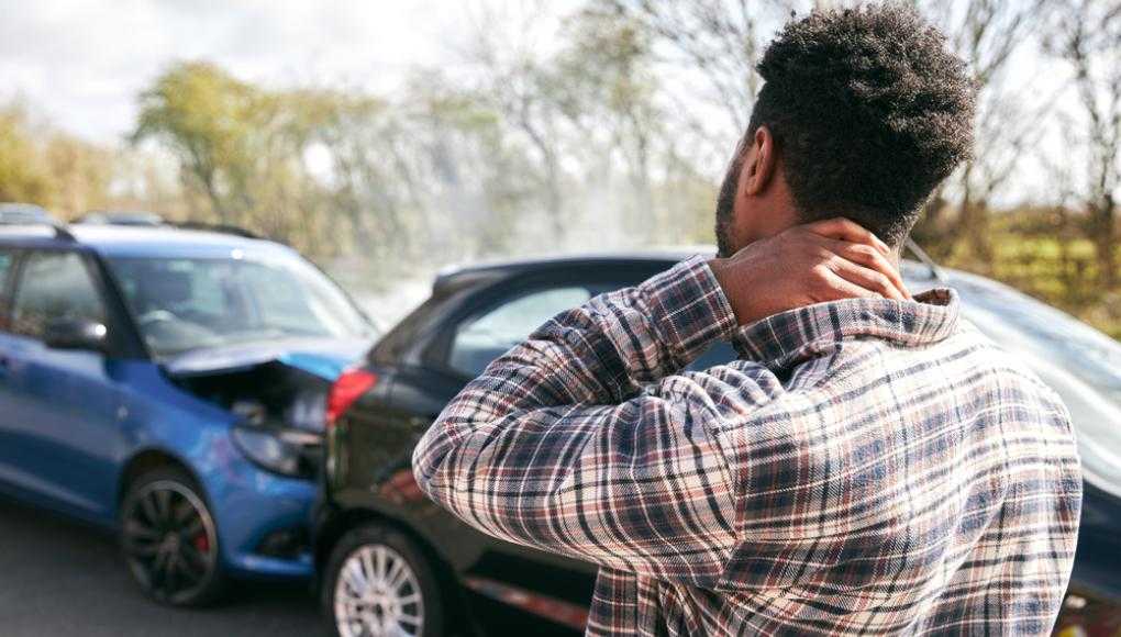 Man rubbing neck in pain after car accident