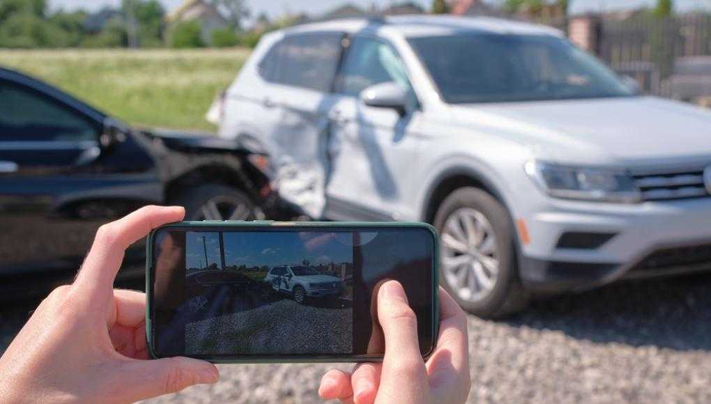 Someone taking a picture of a car crash