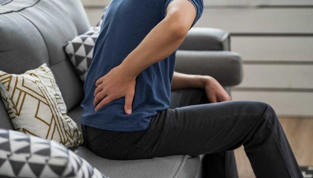 Man sitting on couch with back pain