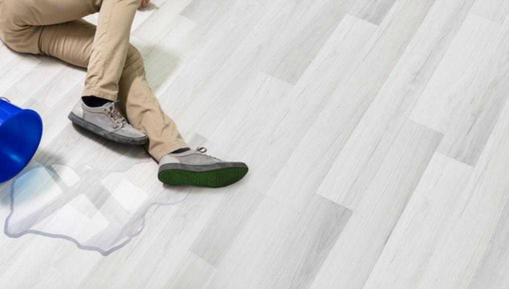 Man fallen on the floor with a spilled bucket of water