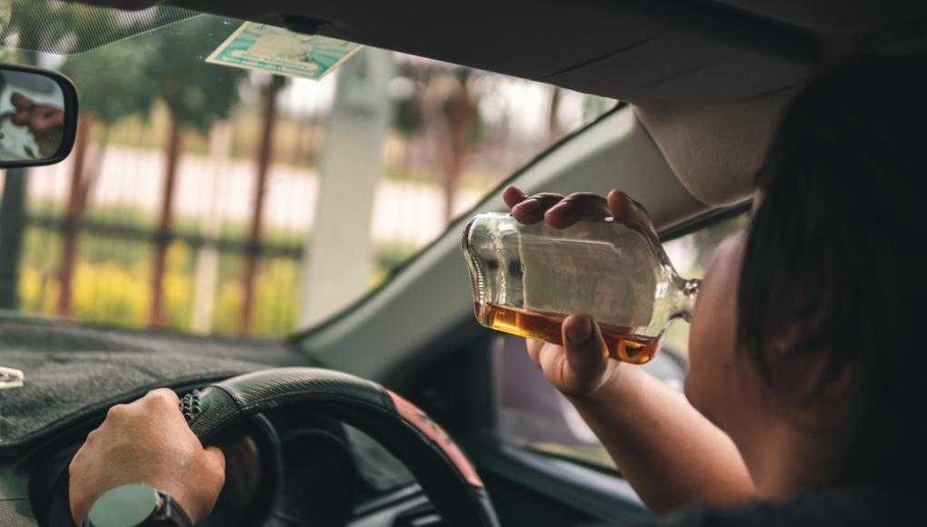 Man drinking alcohol while driving