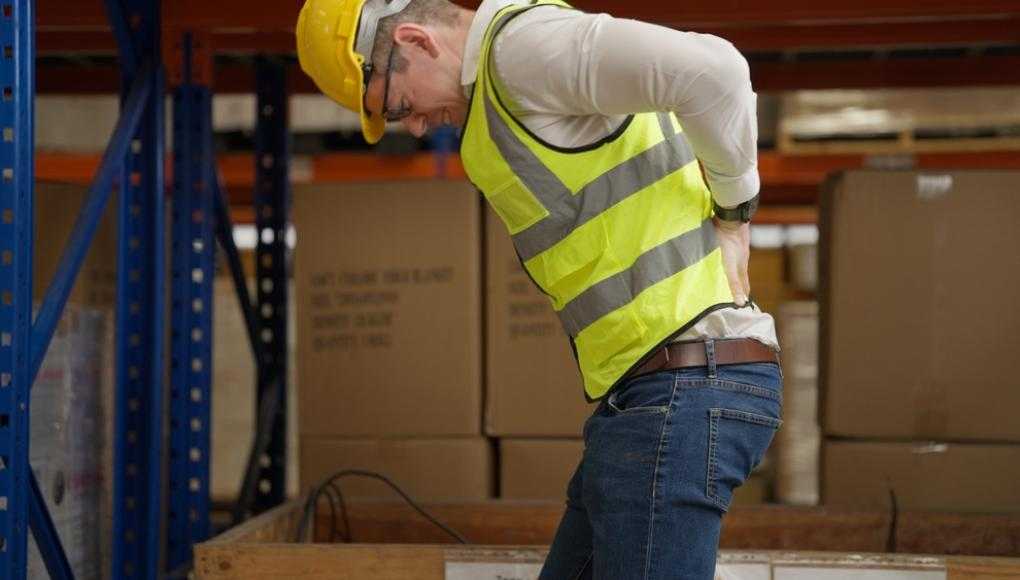 Worker holding back in pain