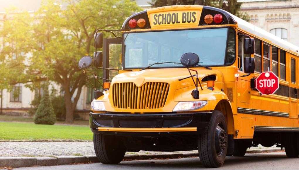 School bus parked next to sidewalk