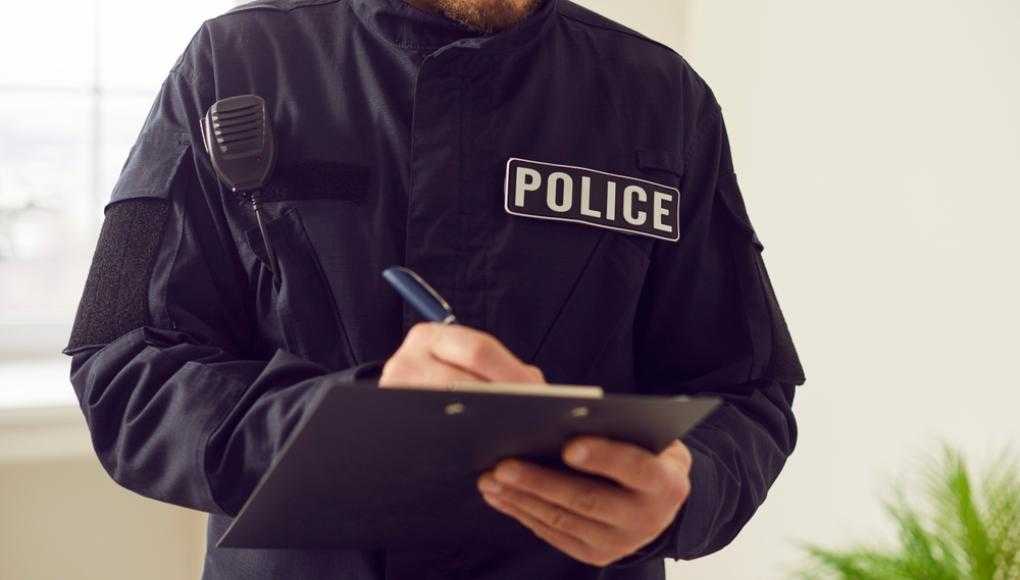 Police office writing on a clipboard