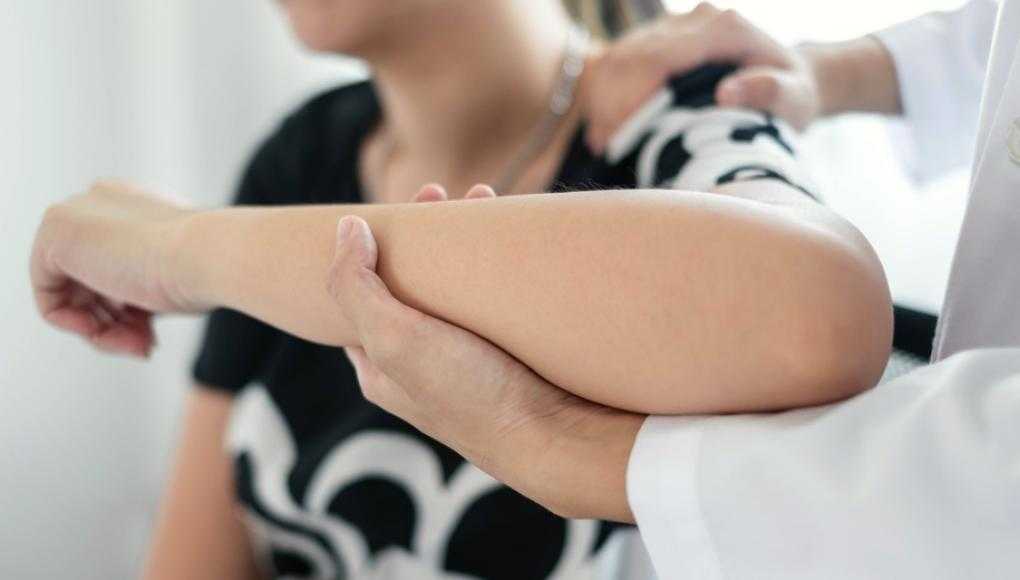 Doctor examining patient's elbow