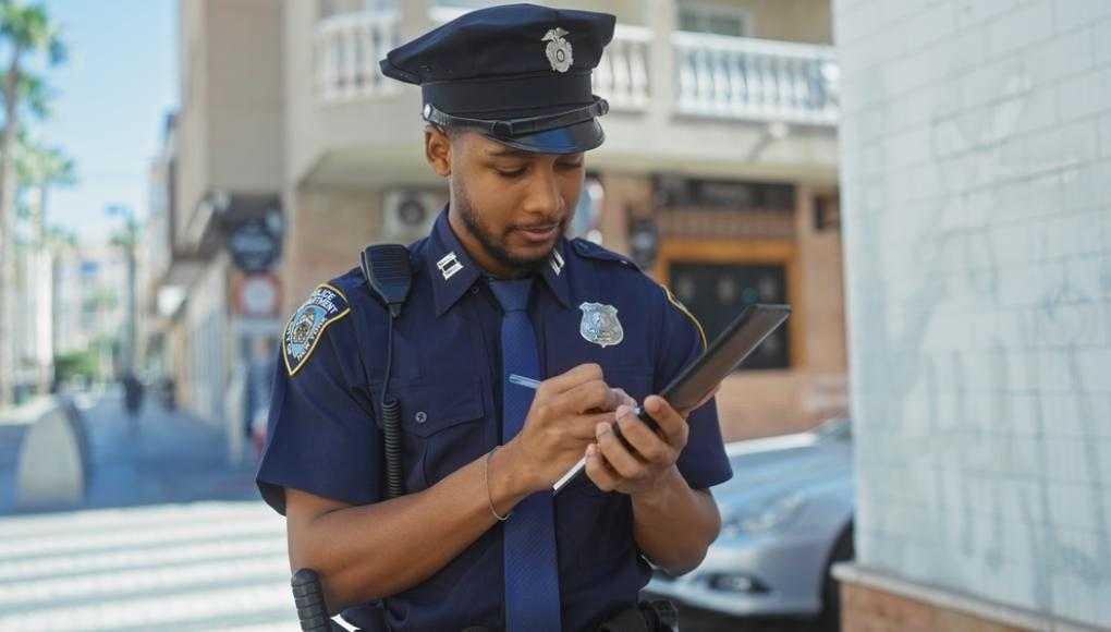 Police officer writing in a notepad 