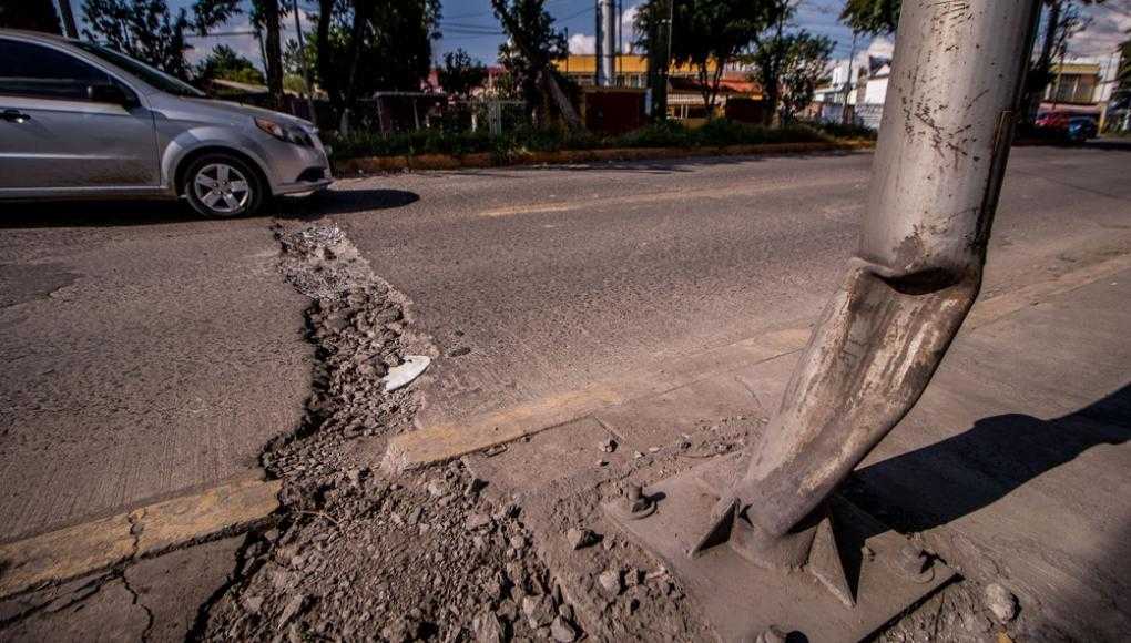 Car driving over a large pothole on the street