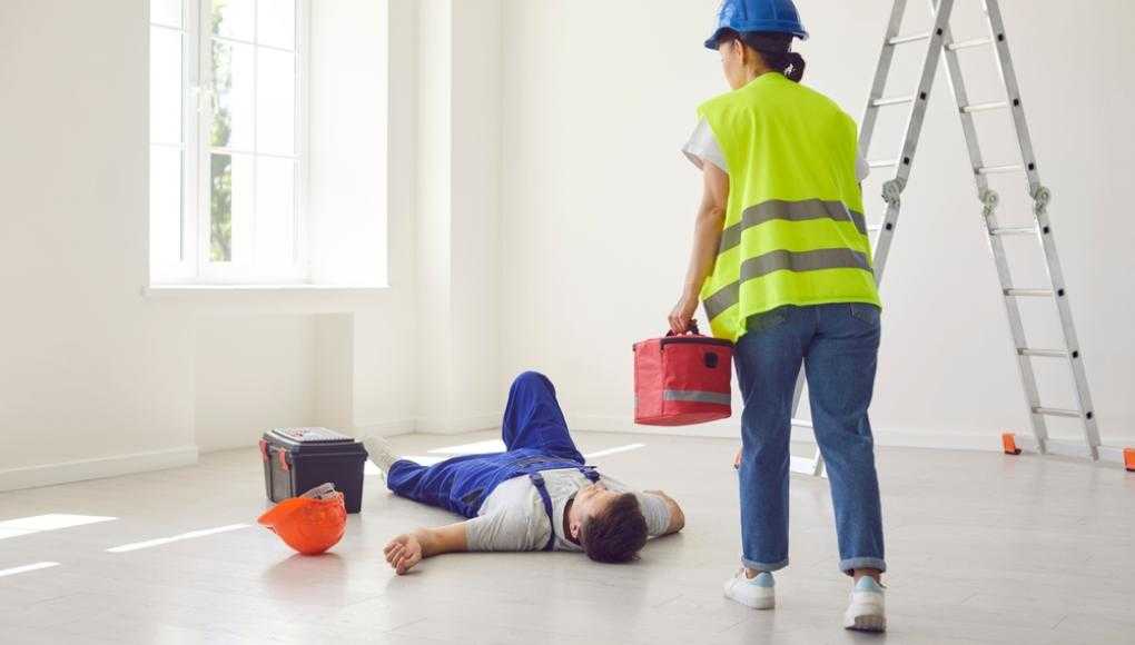 Construction worker helping injured coworker