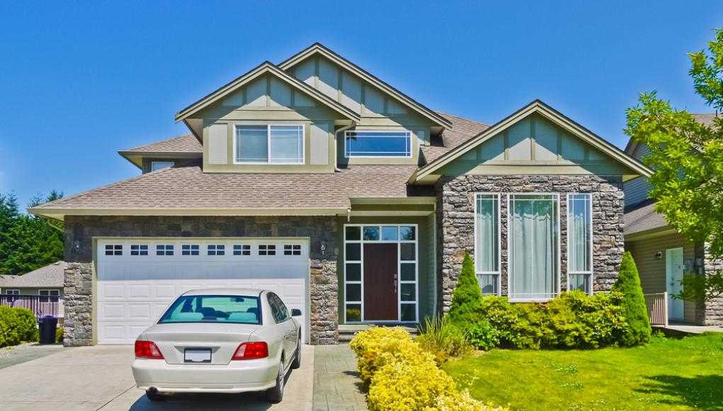 Car parked in the driveway of a suburban house