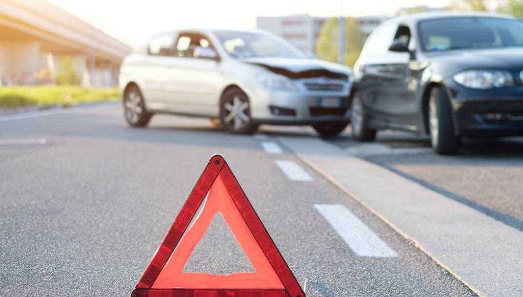 Cone on the road in front of a car accident