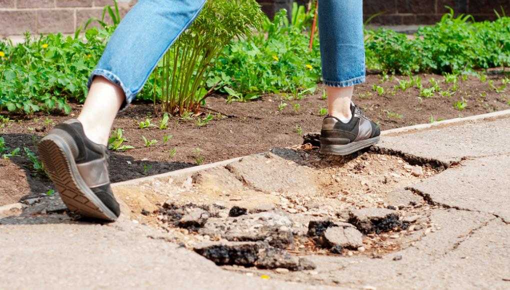 Woman walking over pothole