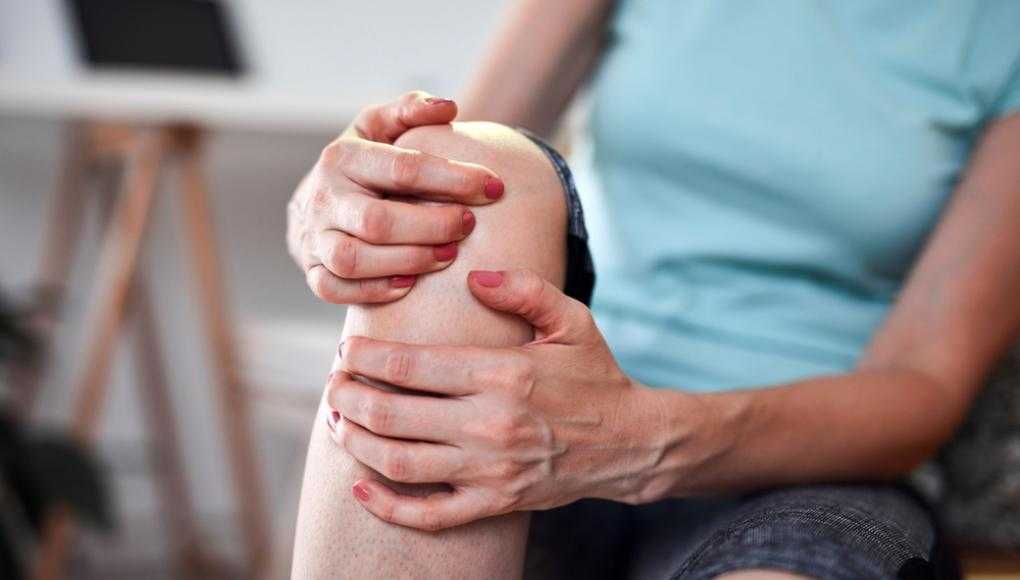 Woman holding her knee is pain