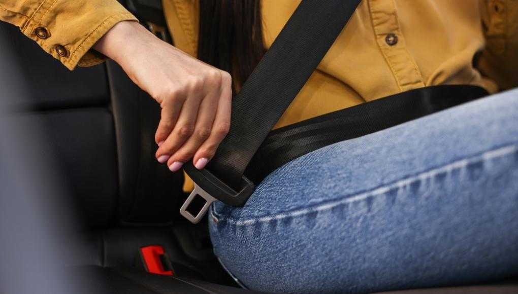 teenager putting on the seatbelt