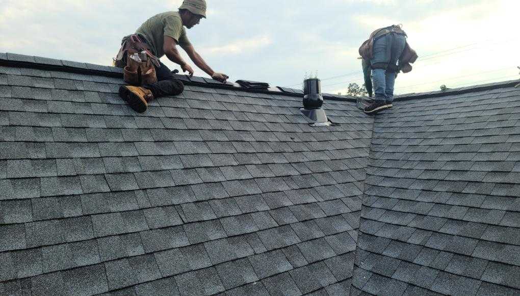 Roofers installing shingles