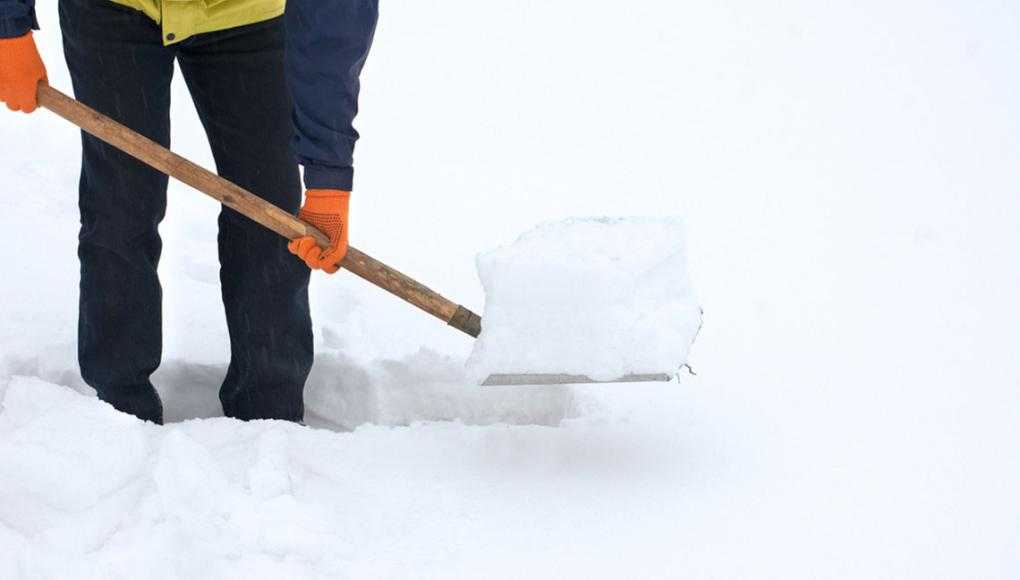 Snowstorm Shopping: Who’s Liable in a Slip and Fall? - A man shoveling a snow