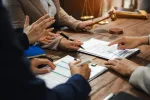 group of employees discussing contract agreement together