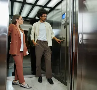 Two people getting into an elevator