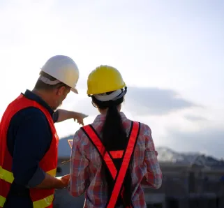 Construction worker helping another worker