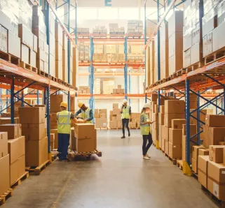 Retail Warehouse full of Shelves with Goods in Cardboard Boxes, Workers Scan and Sort Packages, Move Inventory with Pallet Trucks and Forklifts. Product Distribution Delivery Center.