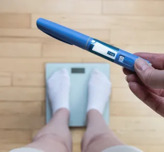 standing on a scale with a weight loss drug