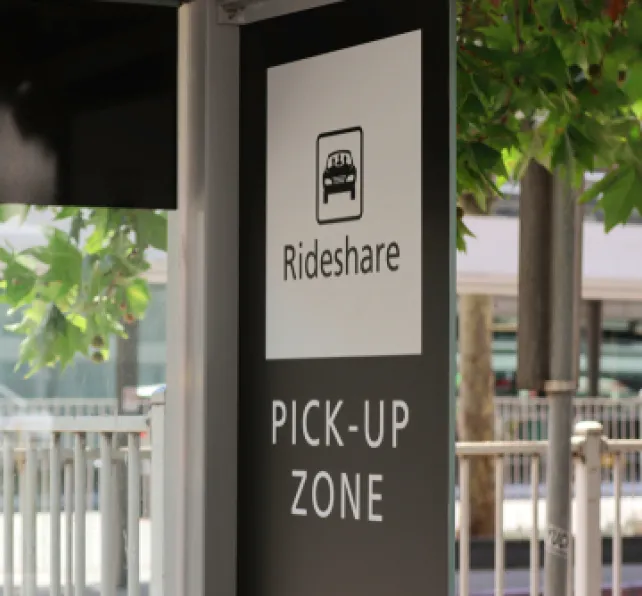 sign for rideshare pick up zone showing a rideshare car