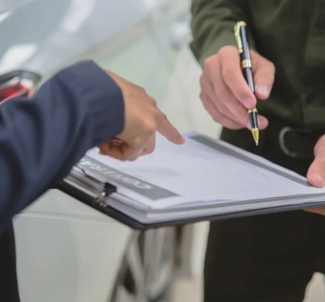 people filing out car insurance claim papers on a clipboard