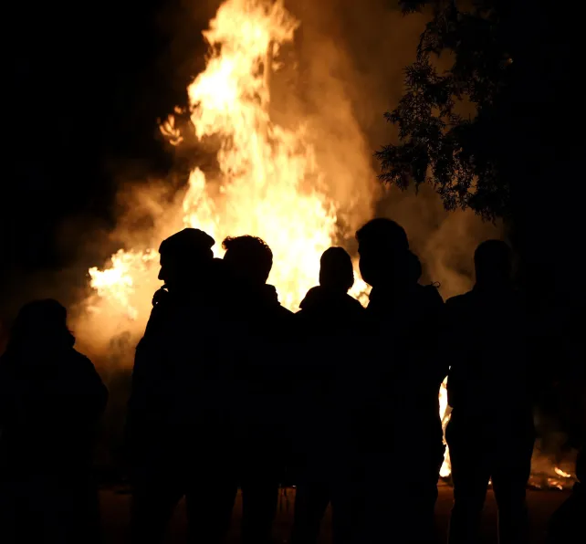 Group standing around fiire