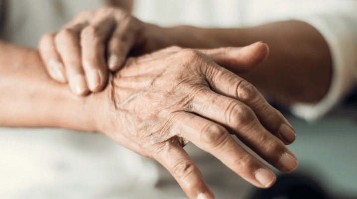 Close up hands of senior elderly woman patient suffering from pakinson's desease symptom