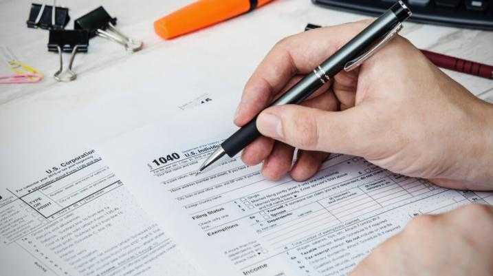 Man filling US tax form. tax form us business income office hand fill concept