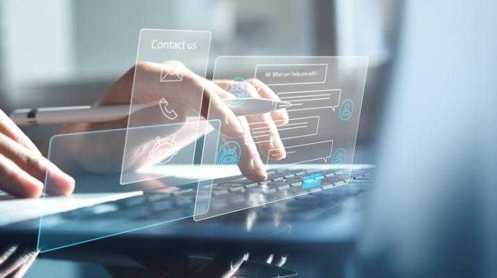 Close-up of hands typing on a laptop with digital customer service interface hologram.