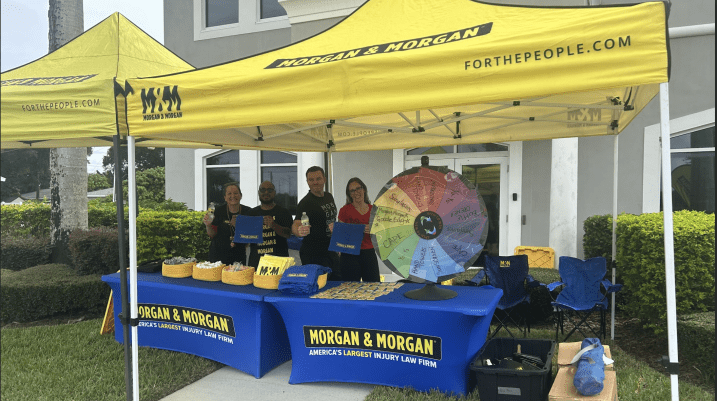 Team of Morgan and Morgan employees smiling by the tent