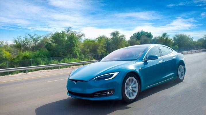 Blue Tesla driving down the road