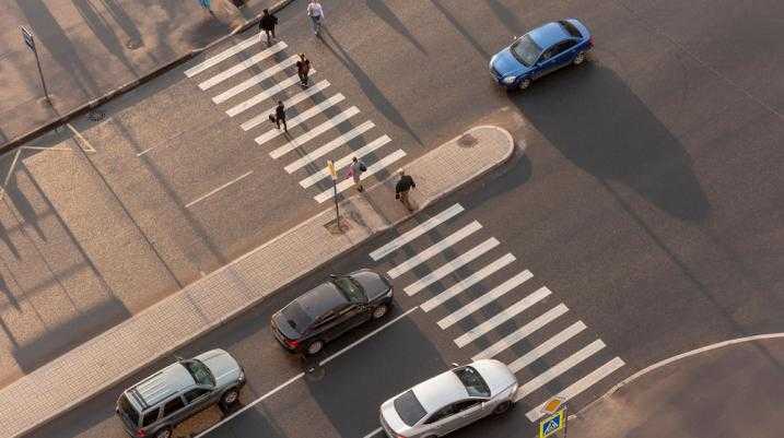 Pedestrians crossing the street with cars