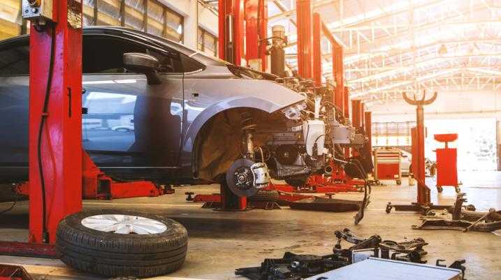 Damaged car lifted in the air in an auto shop